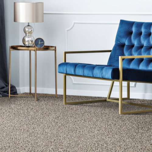 carpet wit blue chair and gold side table with clock and lamp